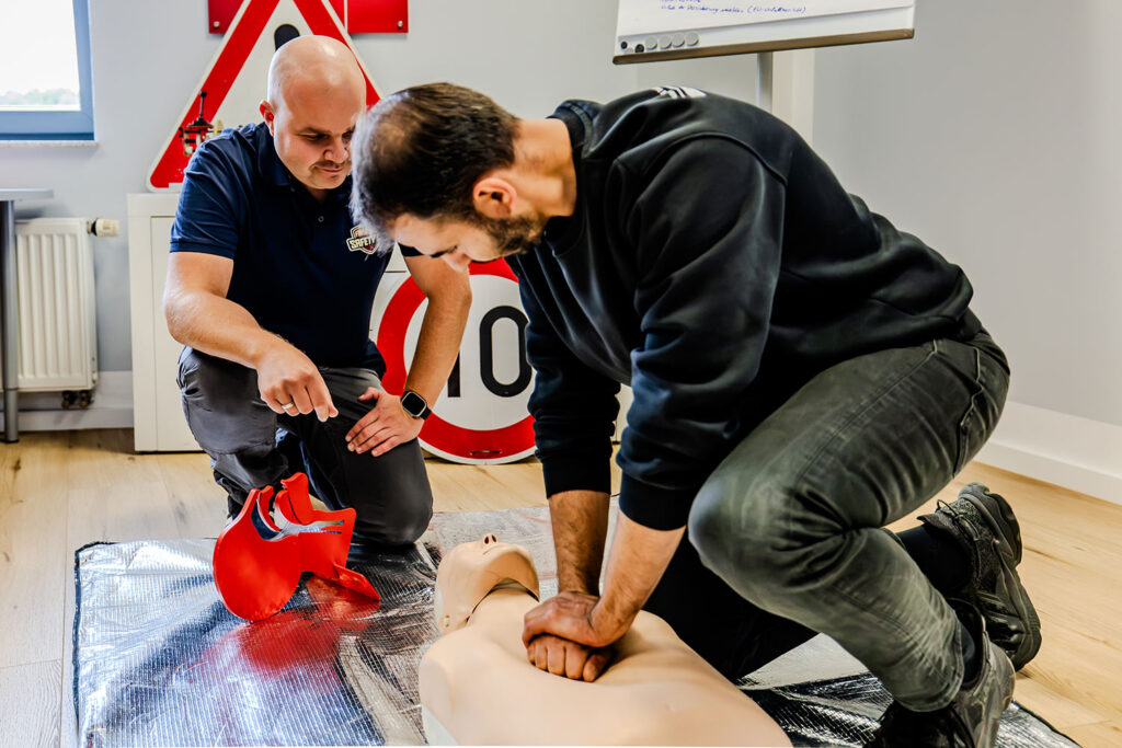 Ein Fahrschüler übt gerade an einer Erste Hilfe Puppe die Herzdruckmassage im Rahmen eines erst Hilfe Lehrgangs.
